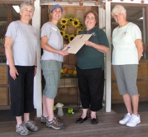 Mary Jordan (3rd from right) of the Department of Agricultural Resources presents Karen Green, Stephanie Waite, and Gail Conlin of Westward Orchards in Harvard, Massachusetts, a proclamation from Gov. Deval Patrick naming September "Apple Month." (Russell Steven Powell photo)